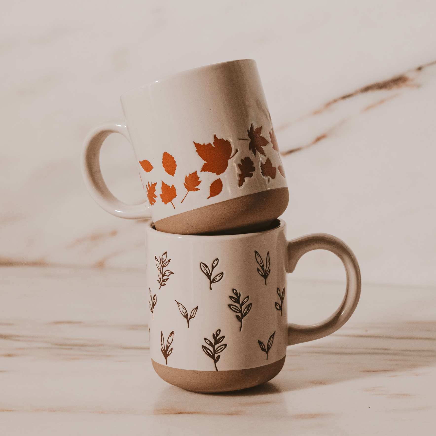 Steingut-Kaffeebecher mit orangenen Blättern