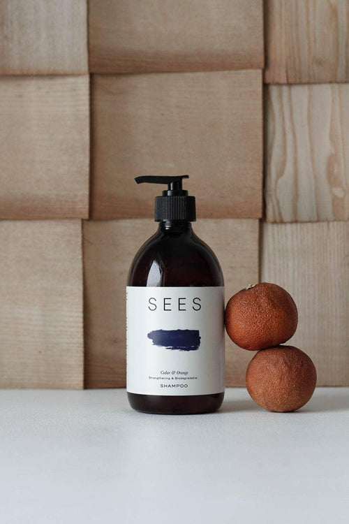 Shampooing Cèdre & Orange de SEES à côté de deux sphères brunes